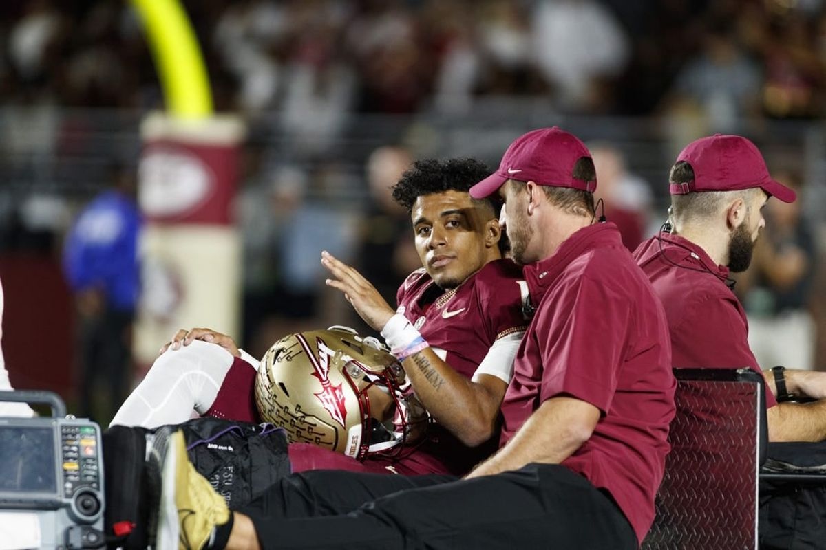 Nov 18, 2023; Tallahassee, Florida, USA; Florida State Seminoles quarterback Jordan Travis (13) waves to fans while being carted off after an injury against the North Alabama Lions during the first quarter at Doak S. Campbell Stadium.