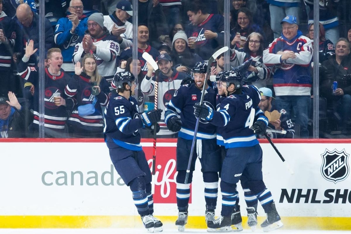 Jan 9, 2024; Winnipeg, Manitoba, CAN; Winnipeg Jets defenseman Brenden Dillon (5) is congratulated by his teammates on his goal against the Columbus Blue Jackets during the first period at Canada Life Centre.