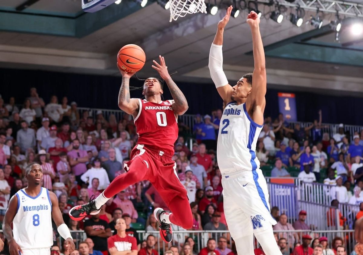 Nov 23, 2023; Paradise Island, BAHAMAS;  Arkansas Razorbacks guard Khalif Battle (0) shoots as Memphis Tigers forward Nick Jourdain (2) defends during the second half at Imperial Arena.