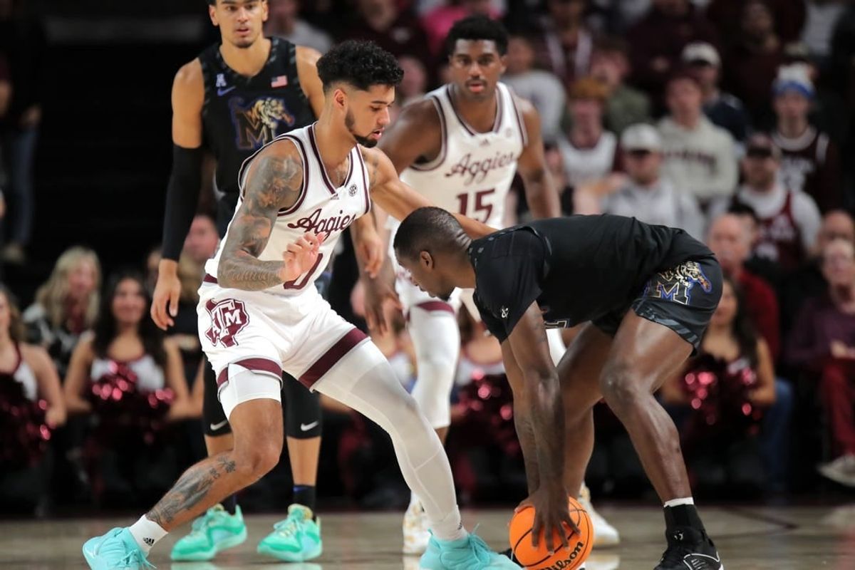 Dec 10, 2023; College Station, Texas, USA; Memphis Tigers forward David Jones (8) handles the ball against Texas A&M Aggies guard Jace Carter (0) during the first half at Reed Arena.