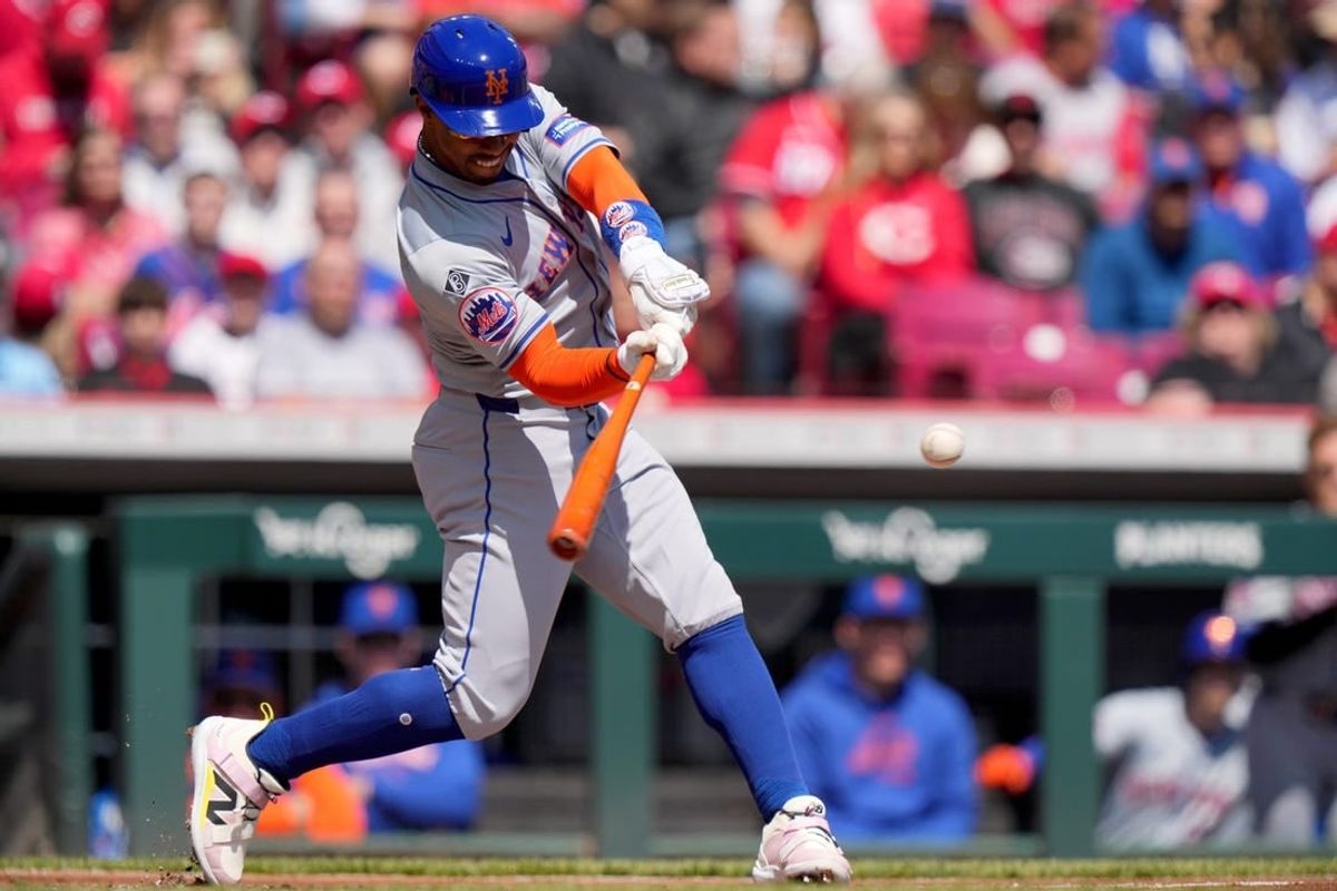 New York Mets shortstop Francisco Lindor (12) hits a double in the first inning of an MLB baseball game against the Cincinnati Reds, Sunday, April 7, 2024, at Great American Ball Park in Cincinnati.
