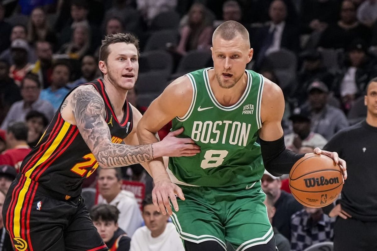 Mar 28, 2024; Atlanta, Georgia, USA; Boston Celtics center Kristaps Porzingis (8) dribbles against Atlanta Hawks guard Garrison Mathews (25) during the first half at State Farm Arena.