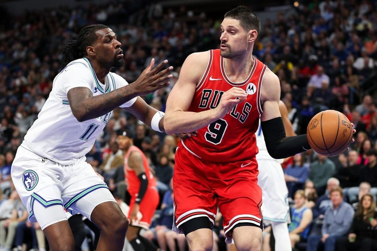 Mar 31, 2024; Minneapolis, Minnesota, USA; Chicago Bulls center Nikola Vucevic (9) passes as Minnesota Timberwolves center Naz Reid (11) defends during the first half at Target Center.