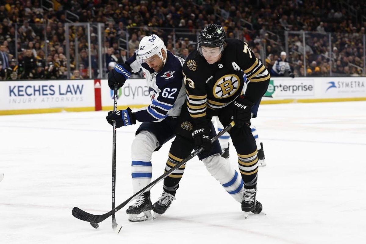 Jan 22, 2024; Boston, Massachusetts, USA; Boston Bruins defenseman Charlie McAvoy (73) and Winnipeg Jets right wing Nino Niederreiter (62) battle for a loose puck during the first period at TD Garden.