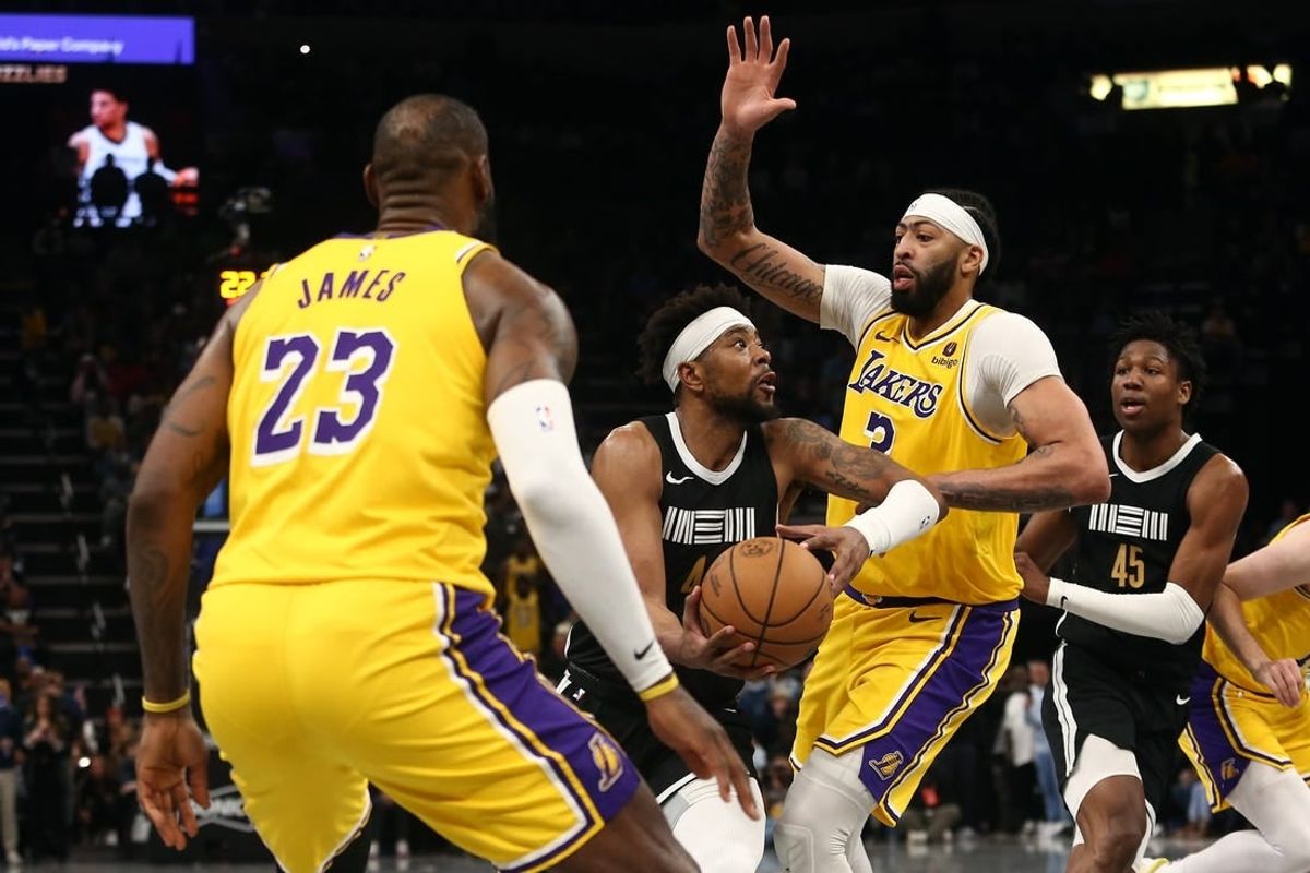 Apr 12, 2024; Memphis, Tennessee, USA; Memphis Grizzlies guard Jordan Goodwin (4) drives to the basket between Los Angeles Lakers forward LeBron James (23) and forward Anthony Davis (3) during the second half at FedExForum.
