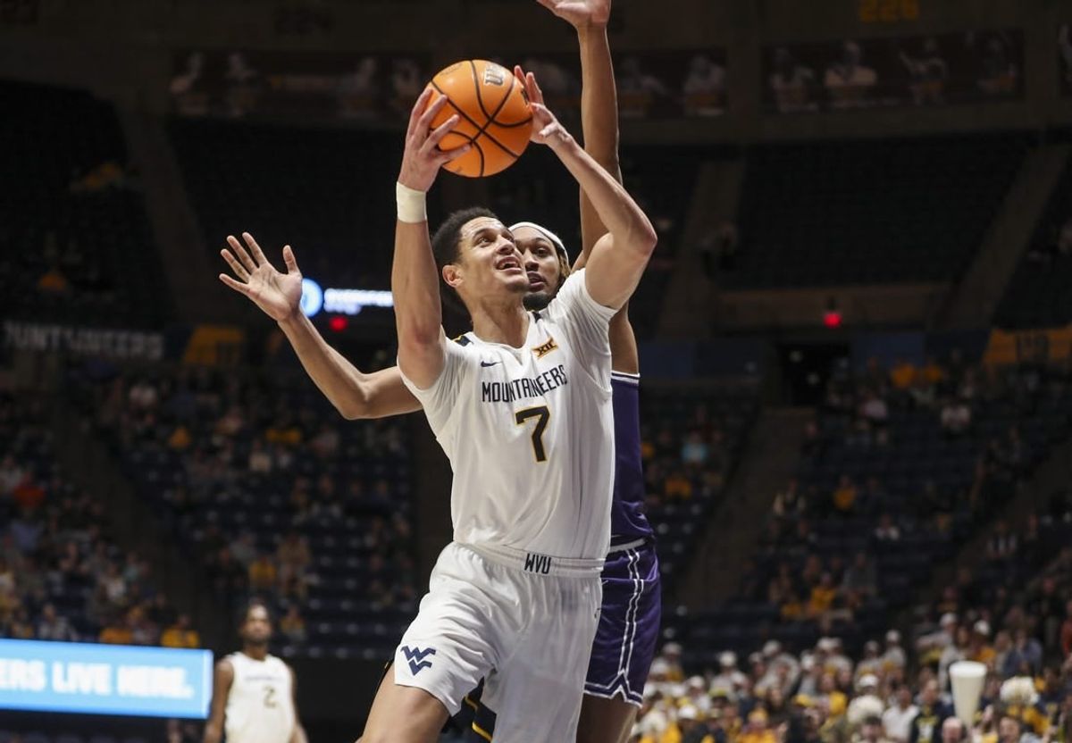 Mar 6, 2024; Morgantown, West Virginia, USA; West Virginia Mountaineers center Jesse Edwards (7) shoots against TCU Horned Frogs forward Xavier Cork (12) during the second half at WVU Coliseum.