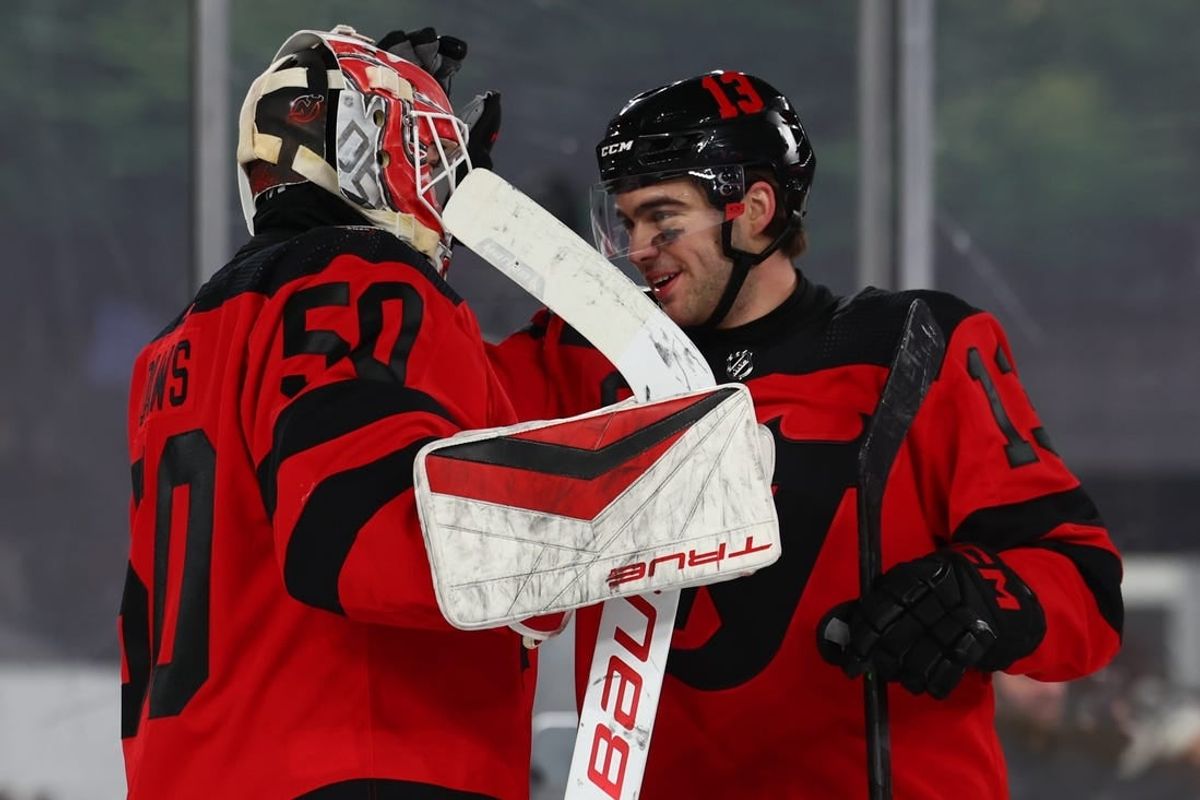Feb 17, 2024; East Rutherford, New Jersey, USA; New Jersey Devils goaltender Nico Daws (50) and center Nico Hischier (13) celebrate their win over the Philadelphia Flyers in a Stadium Series ice hockey game at MetLife Stadium.