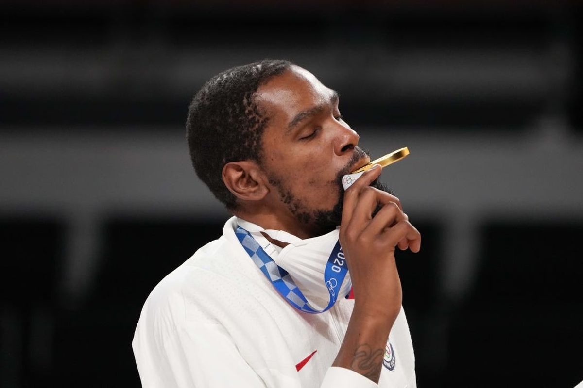 United States forward Kevin Durant bites his gold medal during the Tokyo 2020 Olympic Summer Games at Saitama Super Arena.