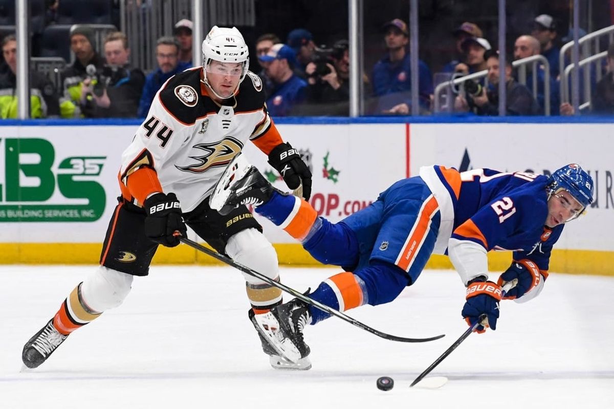 Dec 13, 2023; Elmont, New York, USA; New York Islanders center Kyle Palmieri (21) falls to the ice as Anaheim Ducks left wing Ross Johnston (44) goes after the loose puck during the first period at UBS Arena.