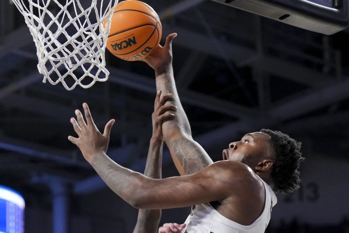 Dec 19, 2023; Cincinnati, Ohio, USA; Cincinnati Bearcats forward Jamille Reynolds (13) attempts a dunk as he is fouled by Merrimack Warriors guard Devon Savage (5) in the first half at Fifth Third Arena.