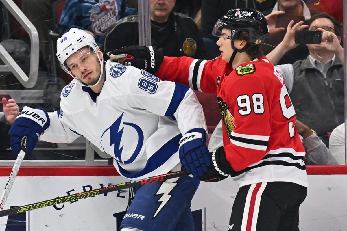 Nov 16, 2023; Chicago, Illinois, USA; Chicago Blackhawks forward Connor Bedard (98) pushes Tampa Bay Lightning defenseman Mikhail Sergachev (98) after Sergachev boarded Chicago Blackhawks forward Philipp Kurashev (23) in the first period at United Center.