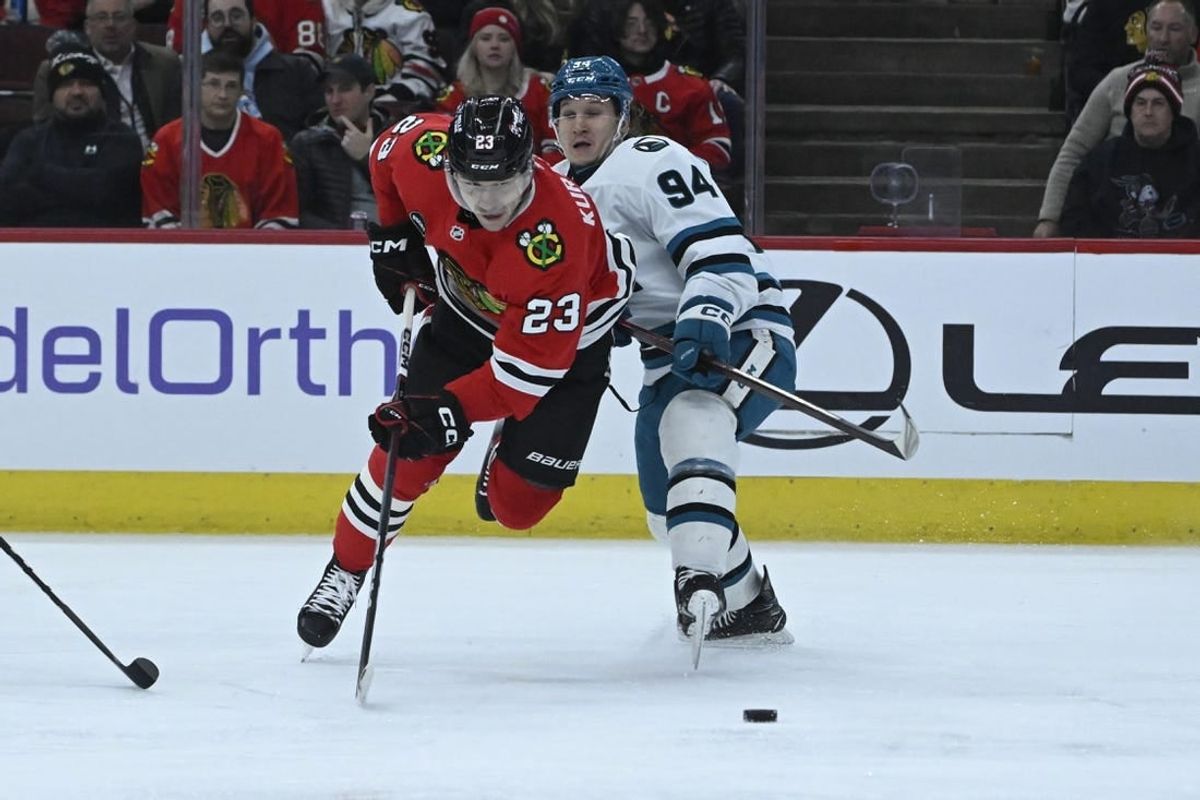 Jan 16, 2024; Chicago, Illinois, USA; Chicago Blackhawks center Philipp Kurashev (23) gets tripped by San Jose Sharks left wing Alexander Barabanov (94) during the first period at United Center.
