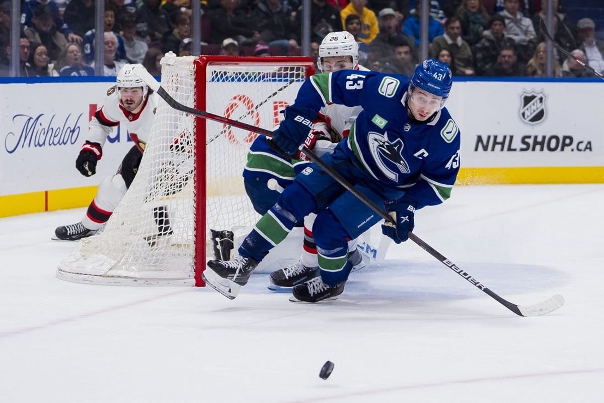 Jan 2, 2024; Vancouver, British Columbia, CAN; Ottawa Senators defenseman Erik Brannstrom (26) and Vancouver Canucks defenseman Quinn Hughes (43) skates after the loose puck in the second period at Rogers Arena.