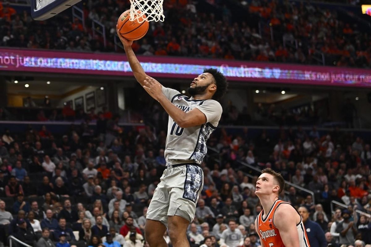 Dec 9, 2023; Washington, District of Columbia, USA; Georgetown Hoyas guard Jayden Epps (10) shoots as Syracuse Orange center Naheem McLeod (10) looks on during the second half at Capital One Arena.