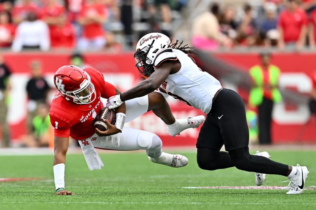 Nov 18, 2023; Houston, Texas, USA; Oklahoma State Cowboys safety Trey Rucker (9) tackles Houston Cougars quarterback Donovan Smith (1) during the first half at TDECU Stadium.