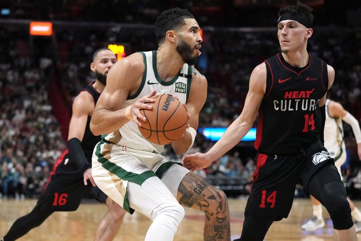 Feb 11, 2024; Miami, Florida, USA;  Boston Celtics forward Jayson Tatum (0) drives to the basket as Miami Heat guard Tyler Herro (14) defends during the first half at Kaseya Center.