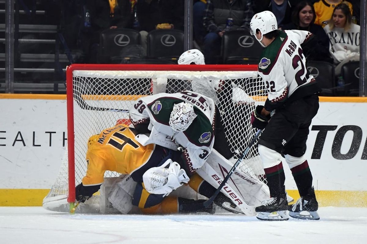 Feb 10, 2024; Nashville, Tennessee, USA; Nashville Predators right wing Michael McCarron (47) draws a penalty as he is hit into Arizona Coyotes goaltender Connor Ingram (39) by center Jack McBain (22) during the second period at Bridgestone Arena.