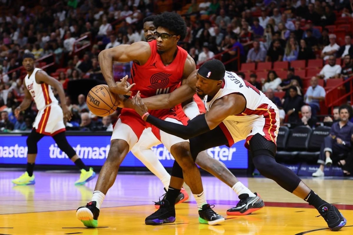 Mar 29, 2024; Miami, Florida, USA; Portland Trail Blazers guard Scoot Henderson (00) and Miami Heat center Bam Adebayo (13) battle for possession during the first quarter at Kaseya Center.