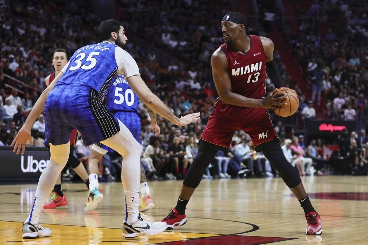 Jan 12, 2024; Miami, Florida, USA; Miami Heat center Bam Adebayo (13) protects the basketball from Orlando Magic center Goga Bitadze (35) during the second quarter at Kaseya Center.