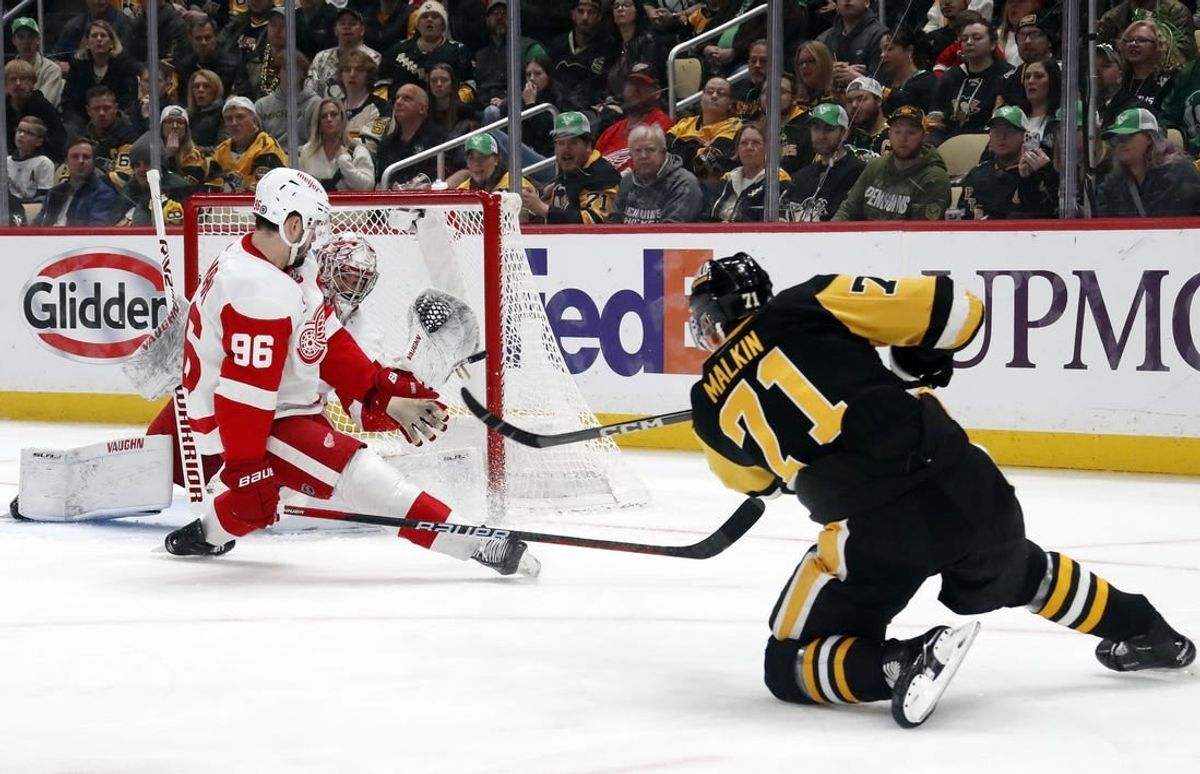 Mar 17, 2024; Pittsburgh, Pennsylvania, USA;  Detroit Red Wings goaltender Alex Lyon (rear) makes a glove save against Pittsburgh Penguins center Evgeni Malkin (71) as Detroit defenseman Jake Walman (96) defends during the first period at PPG Paints Arena.