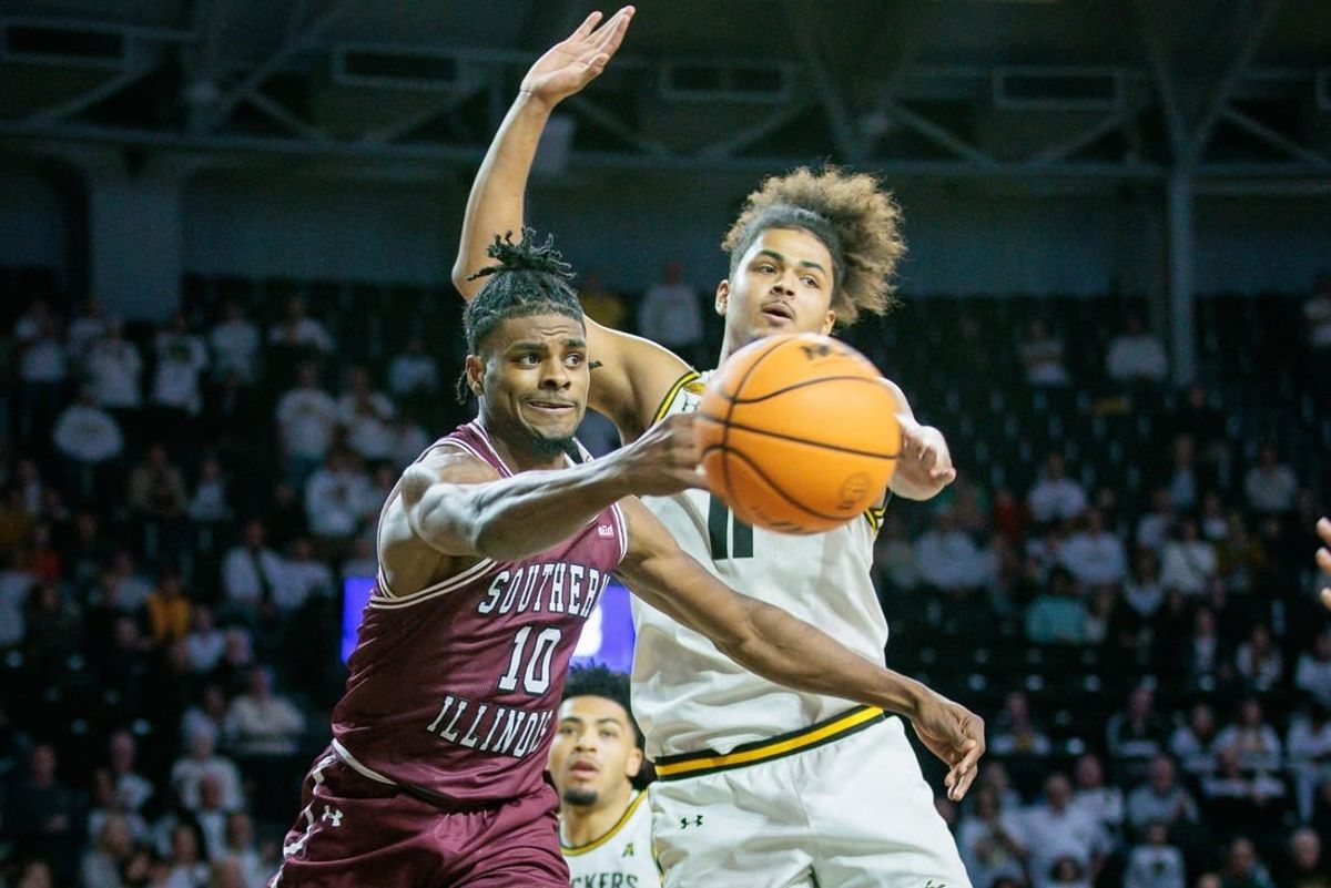 Dec 16, 2023; Wichita, Kansas, USA; Southern Illinois Salukis Xavier Johnson (10) passes around Wichita State Shockers forward Kenny Pohto (11) during the second half at Charles Koch Arena.
