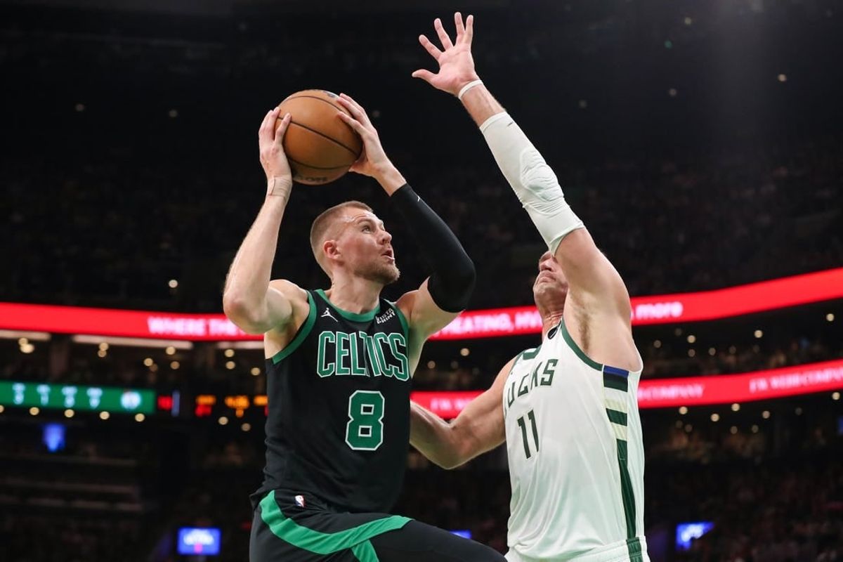 Nov 22, 2023; Boston, Massachusetts, USA; Boston Celtics center Kristaps Porzingis (8) drives to the basket defended by Milwaukee Bucks center Brook Lopez (11) during the first half at TD Garden.