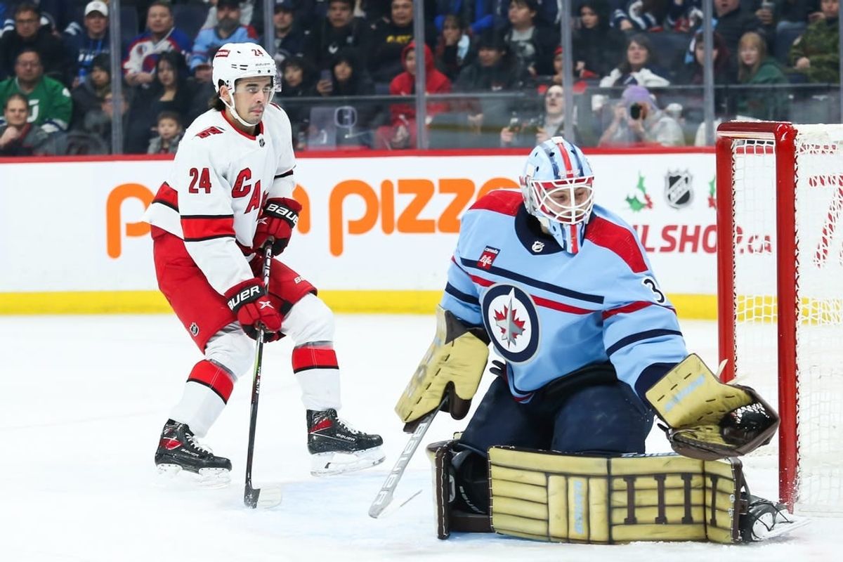 Dec 4, 2023; Winnipeg, Manitoba, CAN; Winnipeg Jets goalie Laurent Boissoit (39) makes a save as Carolina Hurricanes forward Seth Jarvis (24) looks for a rebound during the first period at Canada Life Centre.