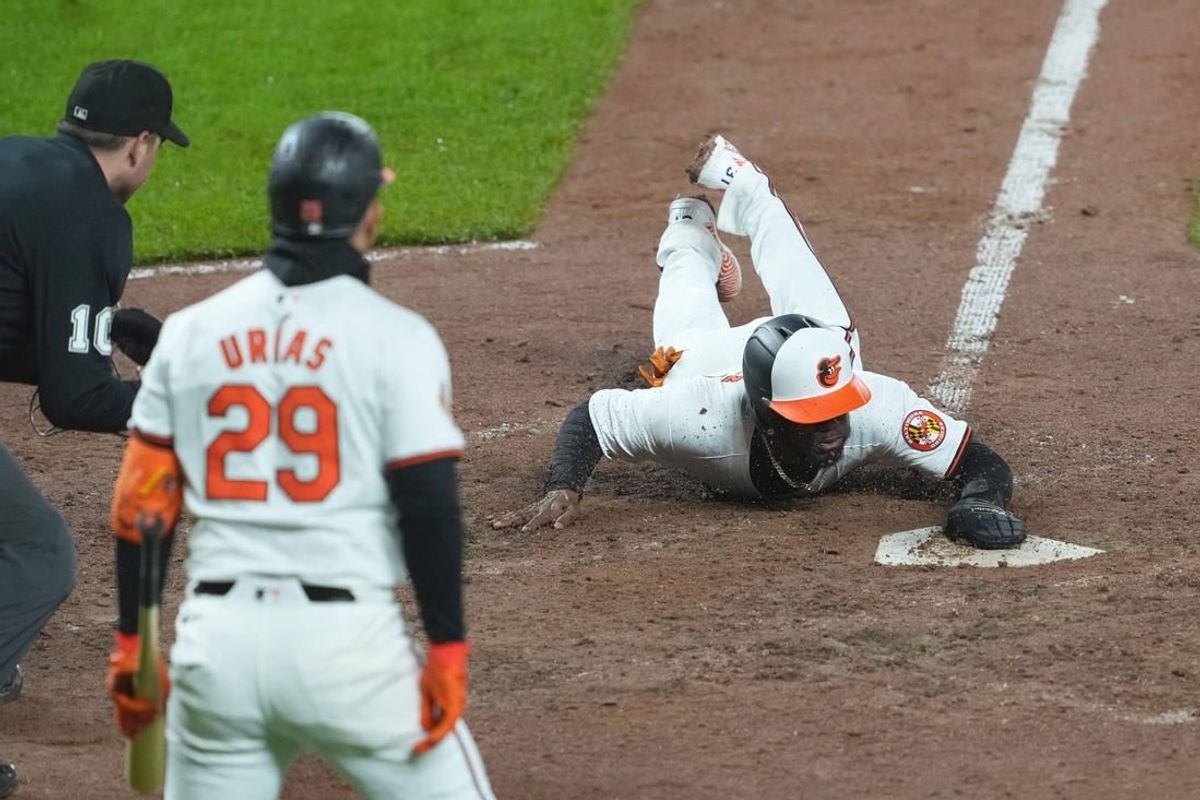 Apr 3, 2024; Baltimore, Maryland, USA; Baltimore Orioles pinch runner Cedric Mullins (31) slides home with the game winning run in the ninth inning against the Kansas City Royals at Oriole Park at Camden Yards.