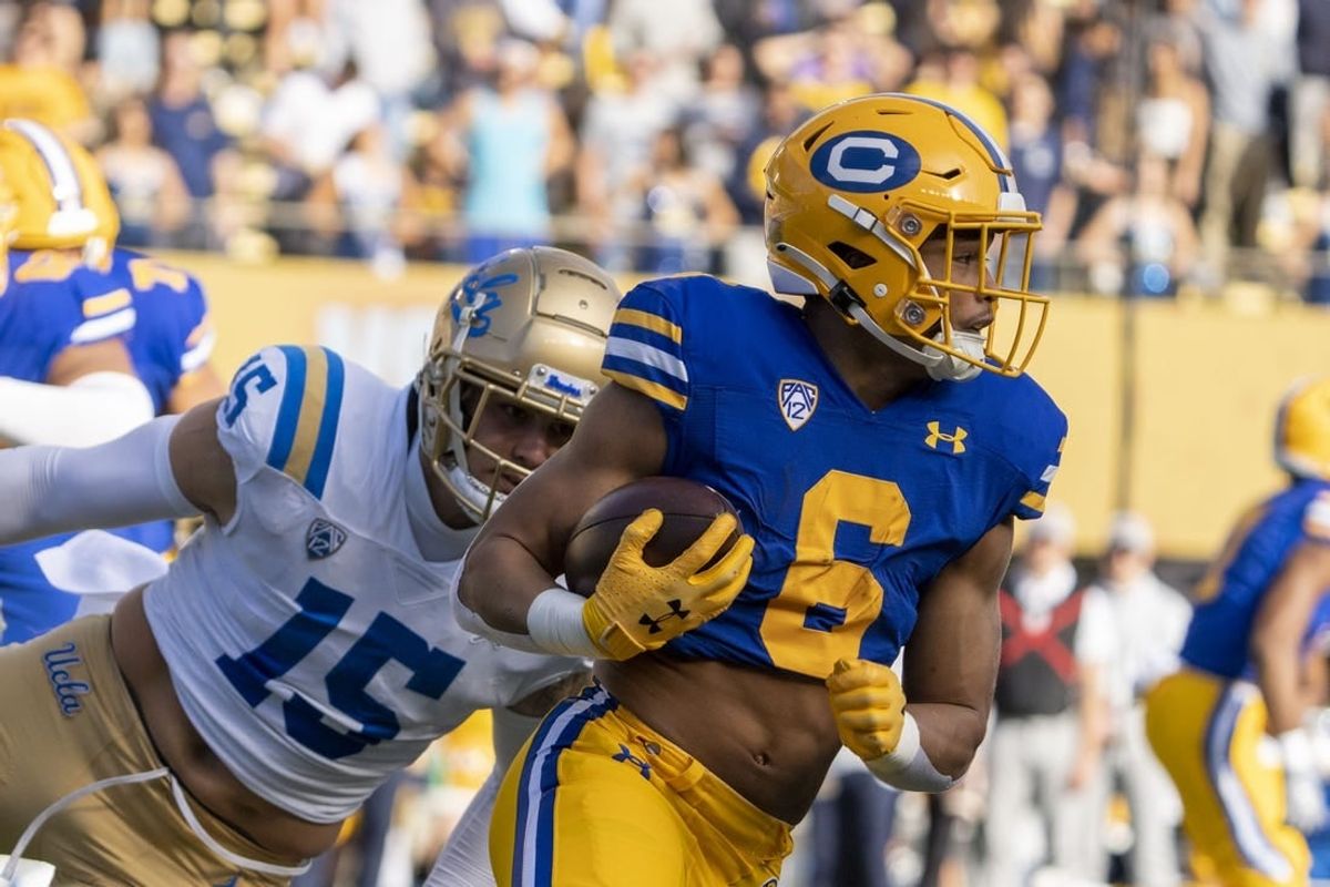November 25, 2022; Berkeley, California, USA; California Golden Bears running back Jaydn Ott (6) runs the football against UCLA Bruins linebacker Laiatu Latu (15) during the first quarter at California Memorial Stadium.