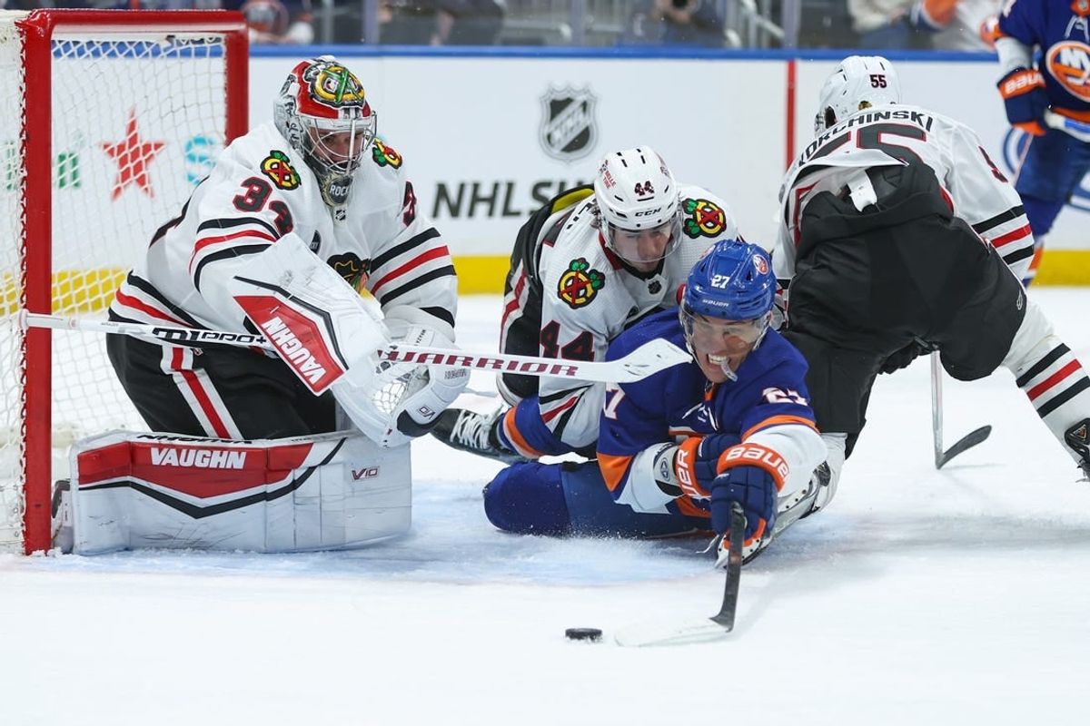Apr 2, 2024; Elmont, New York, USA; New York Islanders left wing Anders Lee (27) attempts to take a shot on Chicago Blackhawks goaltender Petr Mrazek (34) during the second period at UBS Arena.
