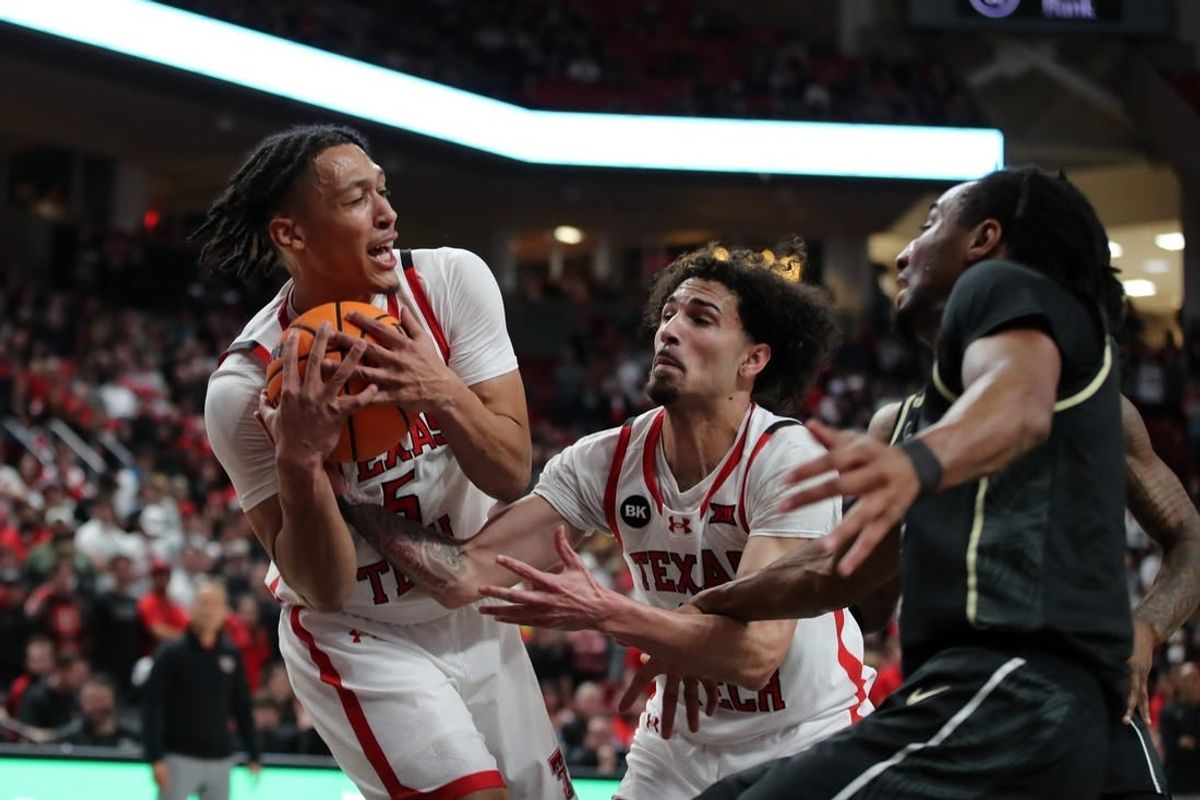 Feb 10, 2024; Lubbock, Texas, USA;  Texas Tech Red Raiders guard Darrion Williams (5) grabs a rebound in front of guard Pop Isaacs (2) and Central Florida Knights guard Shaemarri Allen (2) in the first half United Supermarkets Arena.