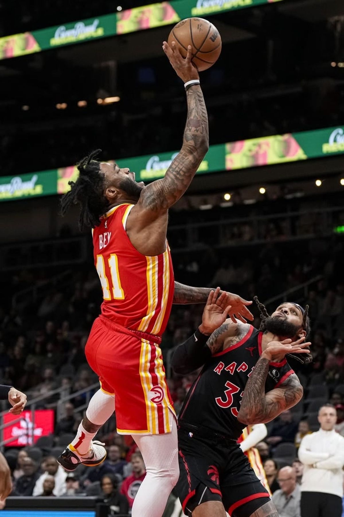 Jan 28, 2024; Atlanta, Georgia, USA; Atlanta Hawks forward Saddiq Bey (41) puts back a rebound over Toronto Raptors guard Gary Trent Jr. (33) during the first half at State Farm Arena.