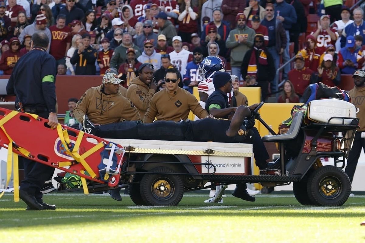 Nov 19, 2023; Landover, Maryland, USA; Washington Commanders defensive end Efe Obada (97) is carted off the field after being injured against the New York Giants during the first quarter at FedExField.
