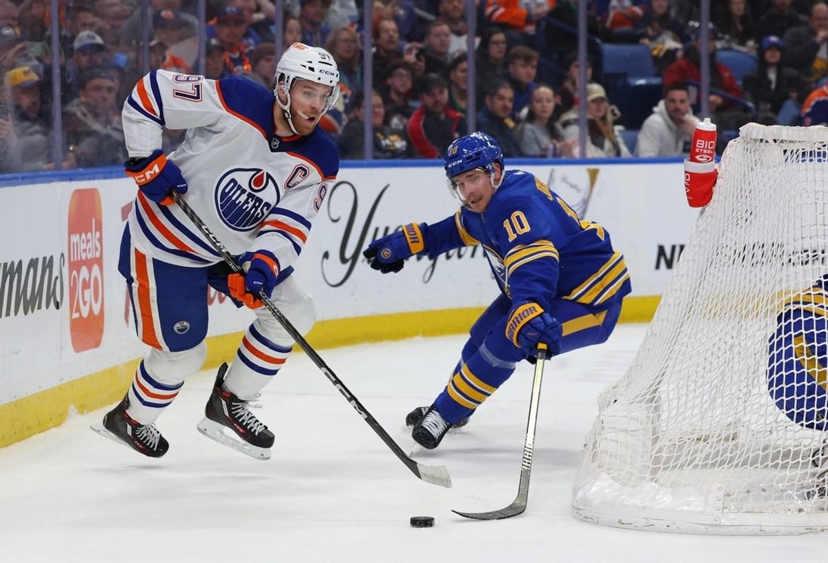 Mar 9, 2024; Buffalo, New York, USA;  Edmonton Oilers center Connor McDavid (97) plays the puck behind the net as Buffalo Sabres defenseman Henri Jokiharju (10) tries to defend during the first period at KeyBank Center.