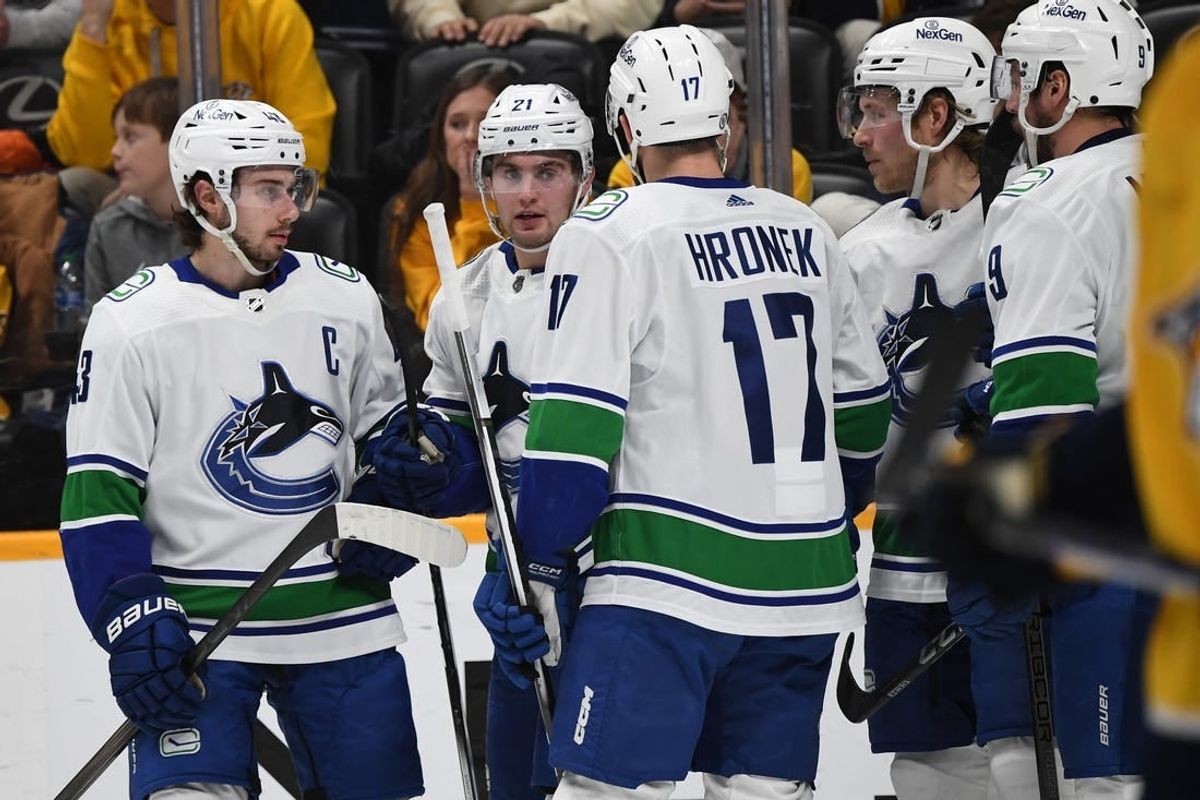 Dec 19, 2023; Nashville, Tennessee, USA; Vancouver Canucks left wing Nils Hoglander (21) celebrates with teammates after a goal during the second period against the Nashville Predators at Bridgestone Arena.