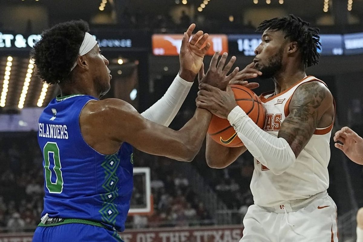 Dec 22, 2023; Austin, Texas, USA; Texas Longhorns guard Tyrese Hunter (4) and Texas A&M Corpus Christi guard Chris Johnson (0) battle for the loose ball during the first half at Moody Center.