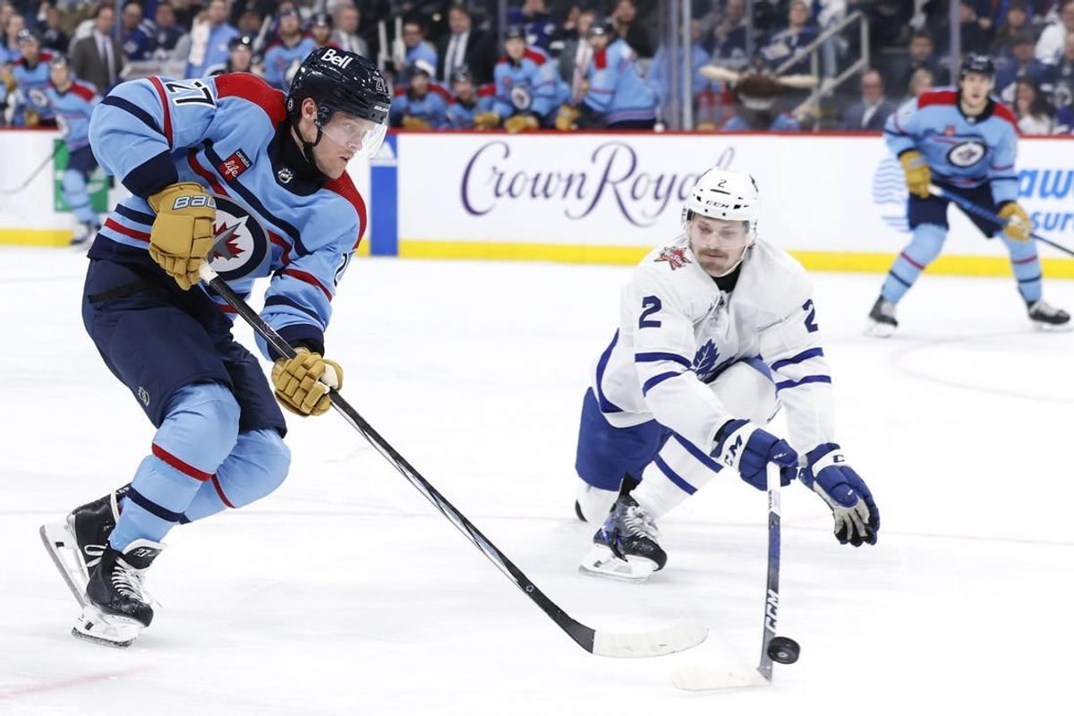 Jan 27, 2024; Winnipeg, Manitoba, CAN; Winnipeg Jets left wing Nikolaj Ehlers (27) is stick checked by Toronto Maple Leafs defenseman Simon Benoit (2) in the second period at Canada Life Centre.