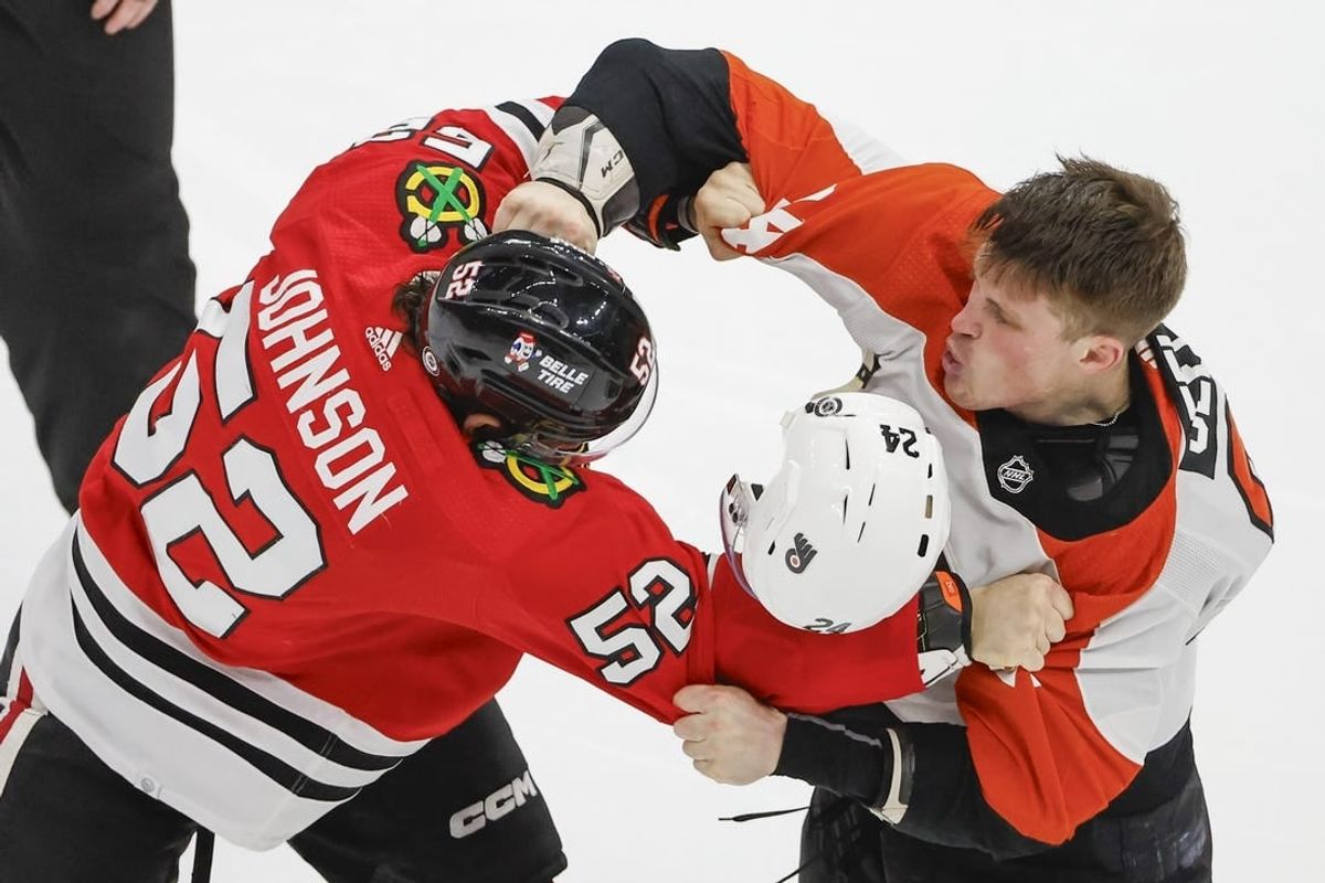 Feb 21, 2024; Chicago, Illinois, USA; Philadelphia Flyers defenseman Nick Seeler (24) fights with Chicago Blackhawks center Reese Johnson (52) during the third period at United Center.