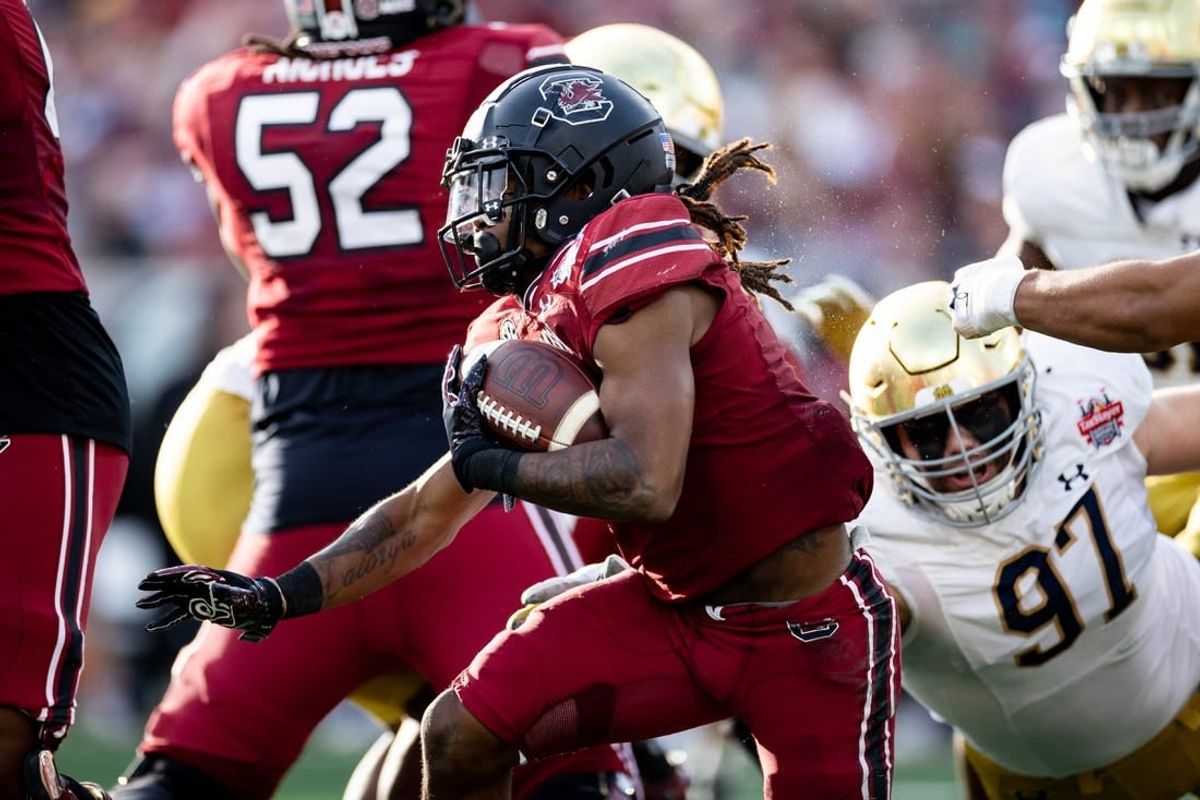 Dec 30, 2022; Jacksonville, FL, USA; South Carolina Gamecocks wide receiver Antwane Wells Jr. (3) runs with the ball away from Notre Dame Fighting Irish defensive lineman Gabriel Rubio (97) during the first half in the 2022 Gator Bowl at TIAA Bank Field.
