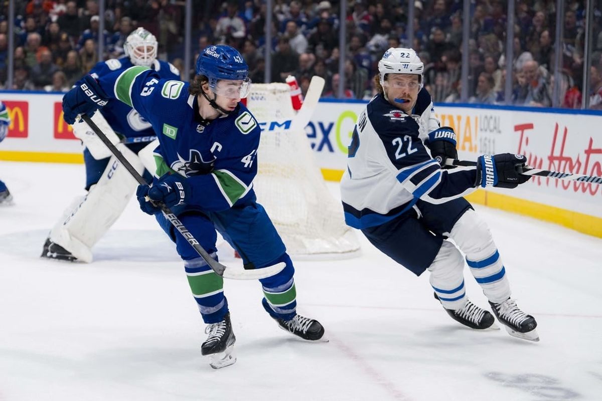 Feb 17, 2024; Vancouver, British Columbia, CAN; Vancouver Canucks defenseman Quinn Hughes (43) battles with Winnipeg Jets forward Mason Appleton (22) in the first period at Rogers Arena.