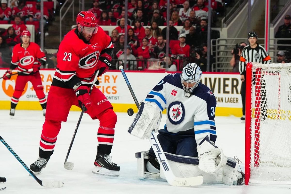 Mar 2, 2024; Raleigh, North Carolina, USA; Winnipeg Jets goaltender Connor Hellebuyck (37) makes a save in front of Carolina Hurricanes right wing Stefan Noesen (23) during the first period at PNC Arena.
