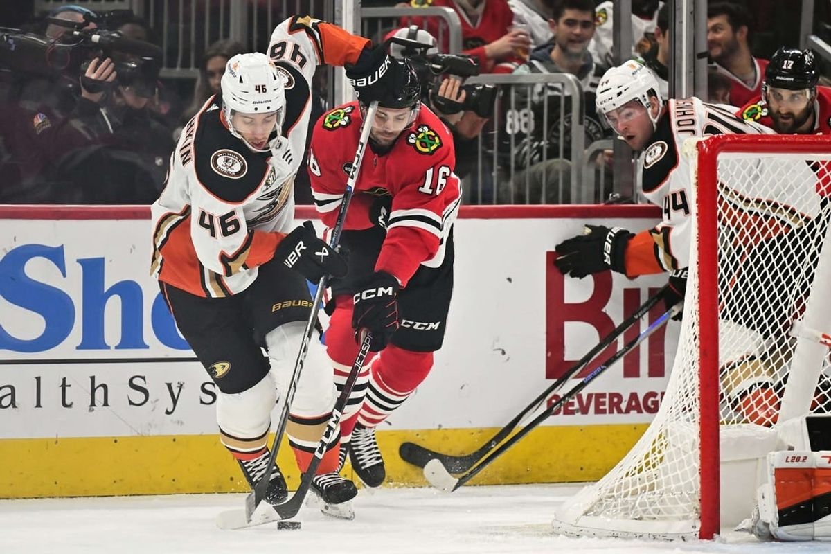 Dec 7, 2023; Chicago, Illinois, USA; Anaheim Ducks defenseman Ilya Lyubushkin (46) and Chicago Blackhawks forward Jason Dickinson (16) battle for control of the puck in the first period at United Center.