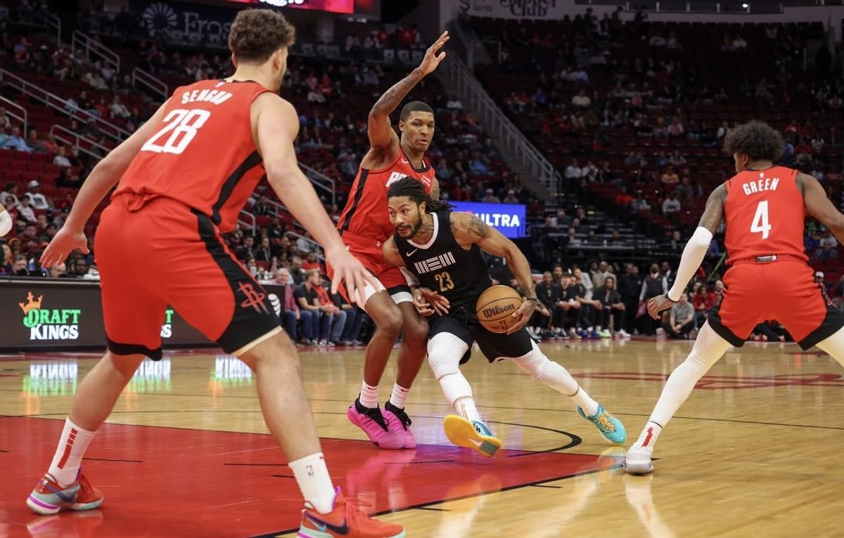 Dec 13, 2023; Houston, Texas, USA; Memphis Grizzlies guard Derrick Rose (23) splits the defense of Houston Rockets forward Jabari Smith Jr. (10) and Hguard Jalen Green (4) and against  center Alperen Sengun (28)  in the first quarter at Toyota Center.