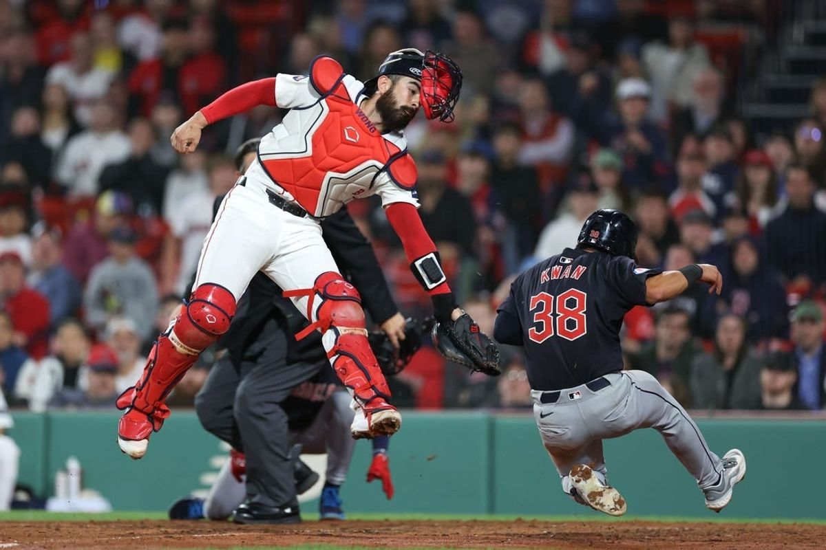 Apr 16, 2024; Boston, Massachusetts, USA; Cleveland Guardians left fielder Steven Kwan (38) slides past a tag from Boston Red Sox catcher Connor Wong (12) during the eleventh inning at Fenway Park.