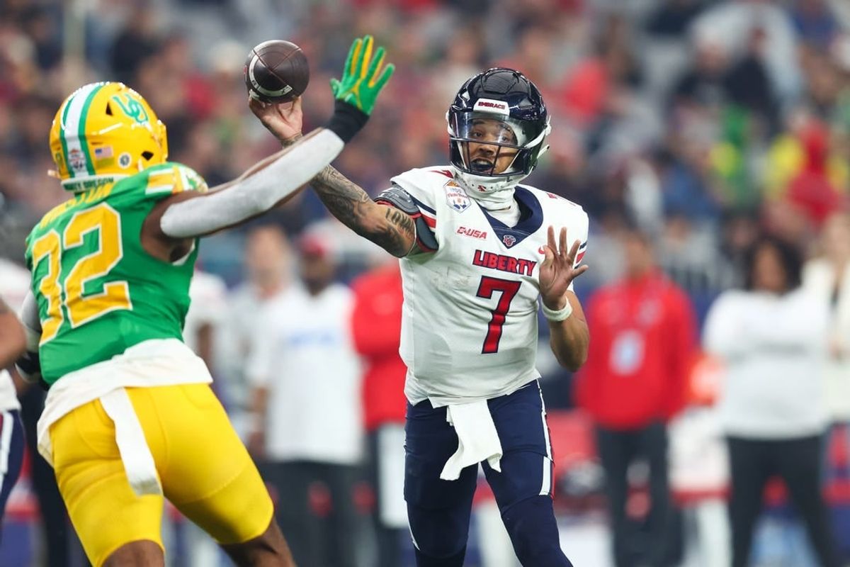Jan 1, 2024; Glendale, AZ, USA; Liberty Flames quarterback Kaidon Salter (7) throws the ball under pressure from Oregon Ducks linebacker Emar'rion Winston (32) during the second half in the 2024 Fiesta Bowl at State Farm Stadium.