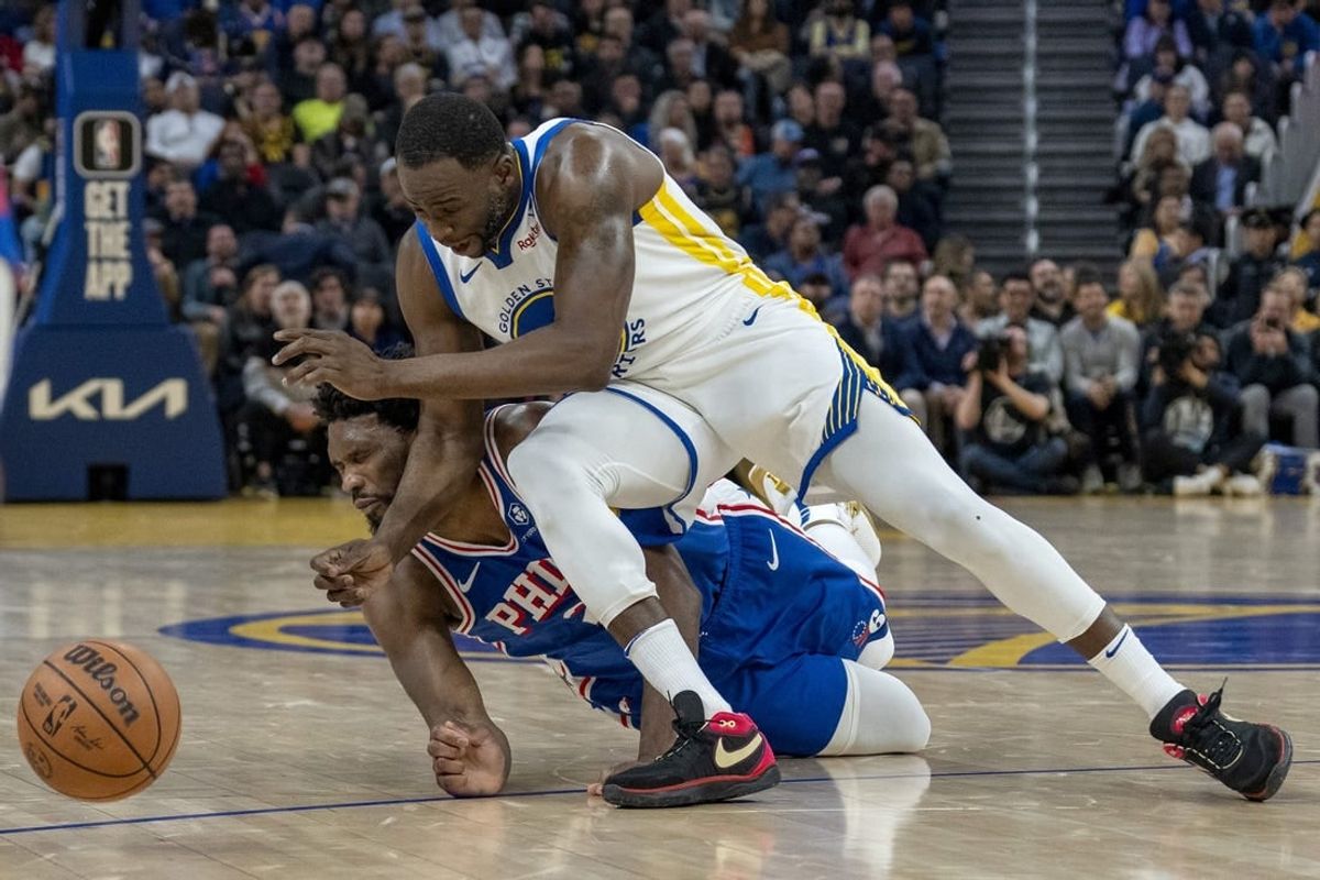 Jan 30, 2024; San Francisco, California, USA;  Philadelphia 76ers center Joel Embiid (21) is called for an offensive foul against Golden State Warriors forward Draymond Green (23) during the second quarter at Chase Center.