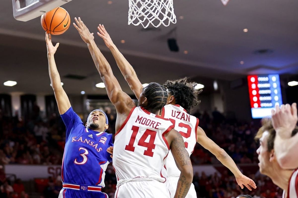 Kansas guard Dajuan Harris Jr. (3) lays up the ball past Oklahoma guard Milos Uzan (12) and Oklahoma forward Jalon Moore (14) in the first half during an NCAA basketball game between The University of Oklahoma (OU) and The University of Kansas (KU), at the Lloyd Noble Center in Norman Okla., on Saturday, Feb. 17, 2024.