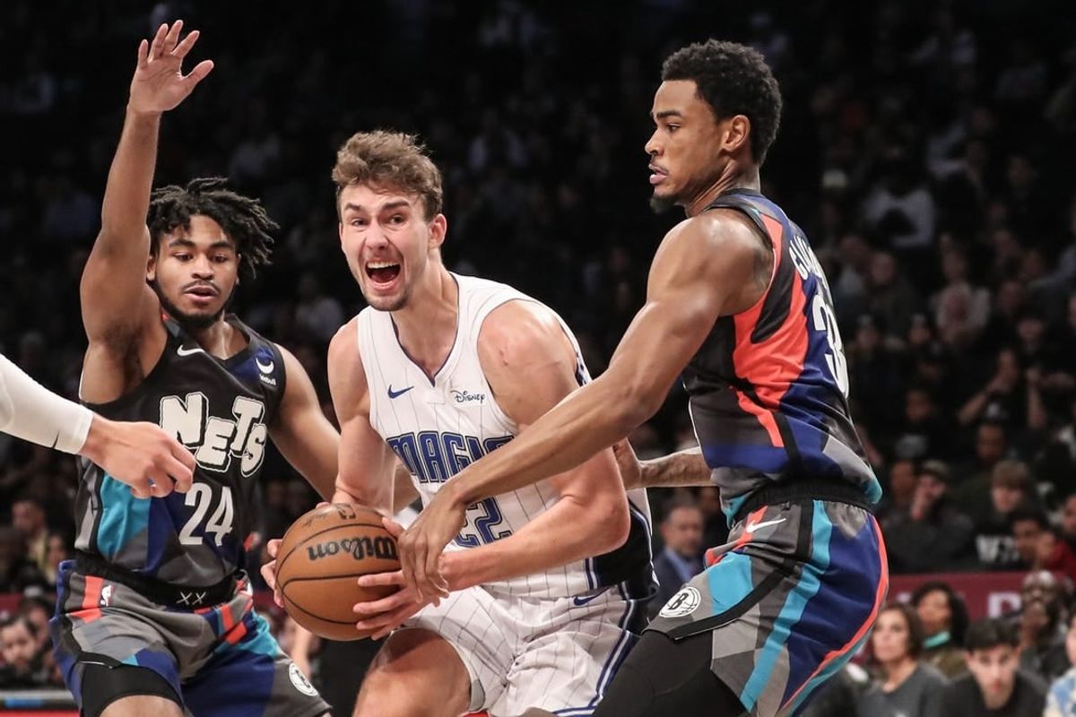 Dec 2, 2023; Brooklyn, New York, USA;  Orlando Magic forward Franz Wagner (22) looks to drive in between Brooklyn Nets guard Cam Thomas (24) and center Nic Claxton (33) in the second quarter at Barclays Center.