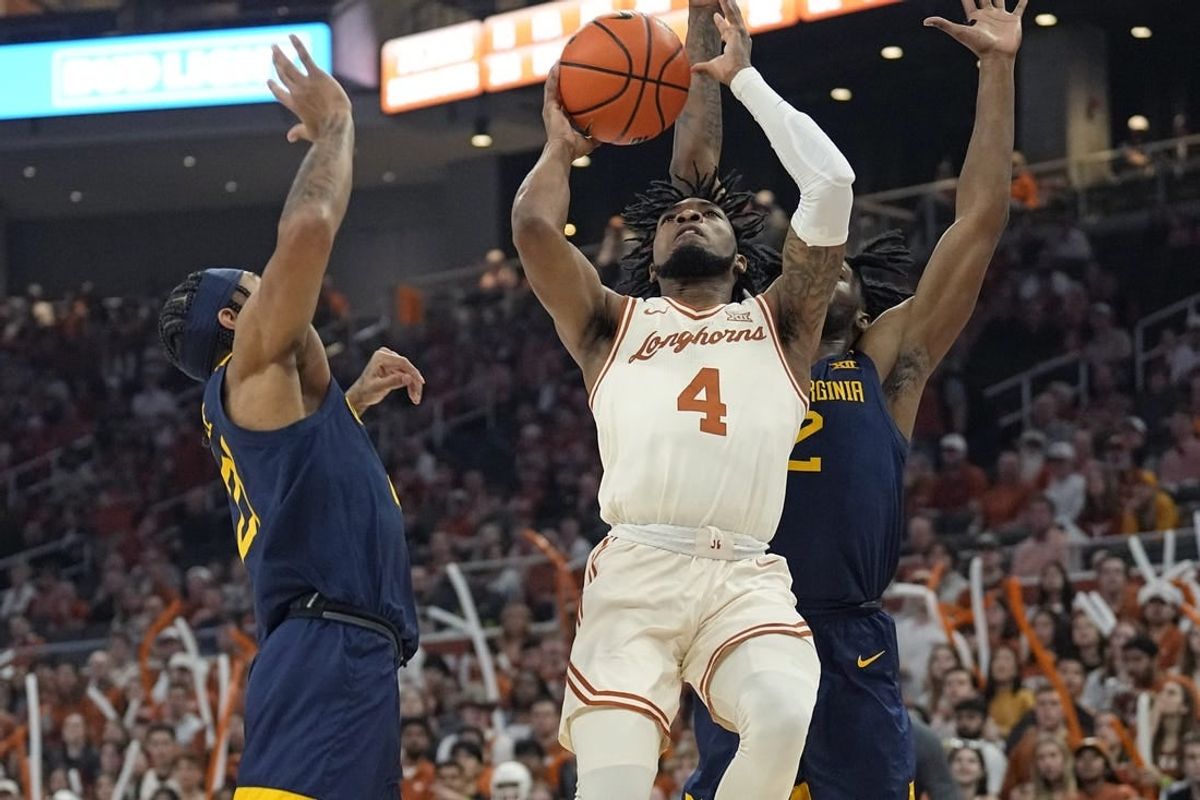Feb 10, 2024; Austin, Texas, USA; Texas Longhorns guard Tyrese Hunter (4) shoots against West Virginia Mountaineers guards RaeQuan Battle (21) and Kobe Johnson (2) during the first half at Moody Center.