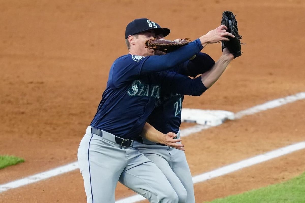 Apr 21, 2024; Denver, Colorado, USA; Seattle Mariners starting pitcher Emerson Hancock (62) and first base Ty France (23) collide fielding a pop fly in the fourth inning against the Colorado Rockies at Coors Field.